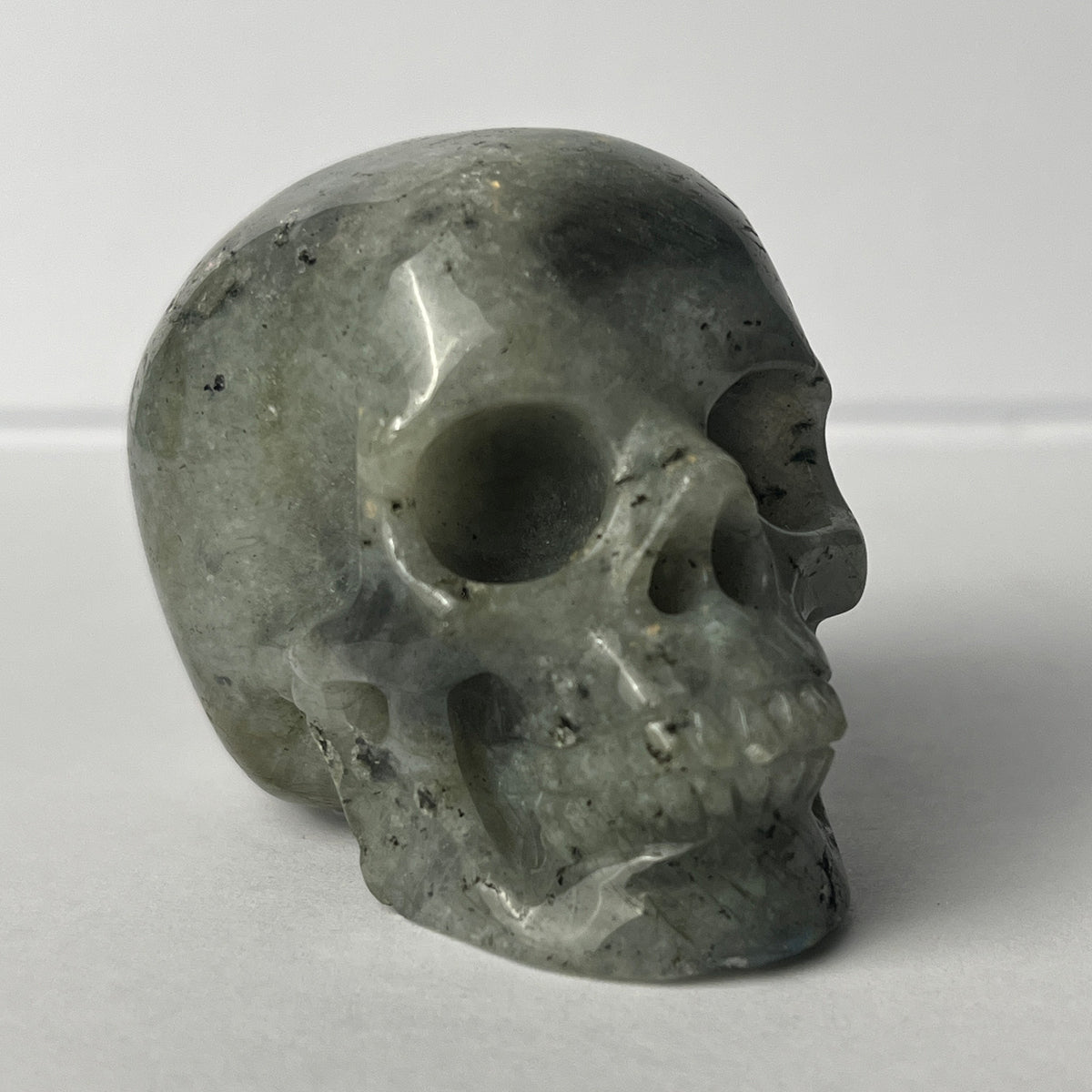 Right-front view of a 2-inch Grey Labradorite human skull carving
