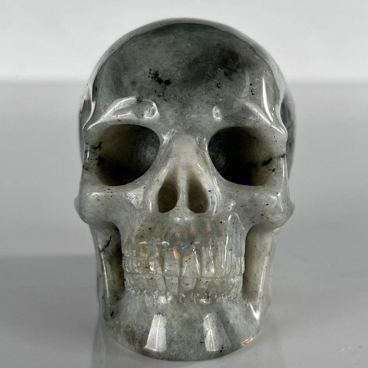 Front view of a 3-inch Grey Labradorite human skull carving