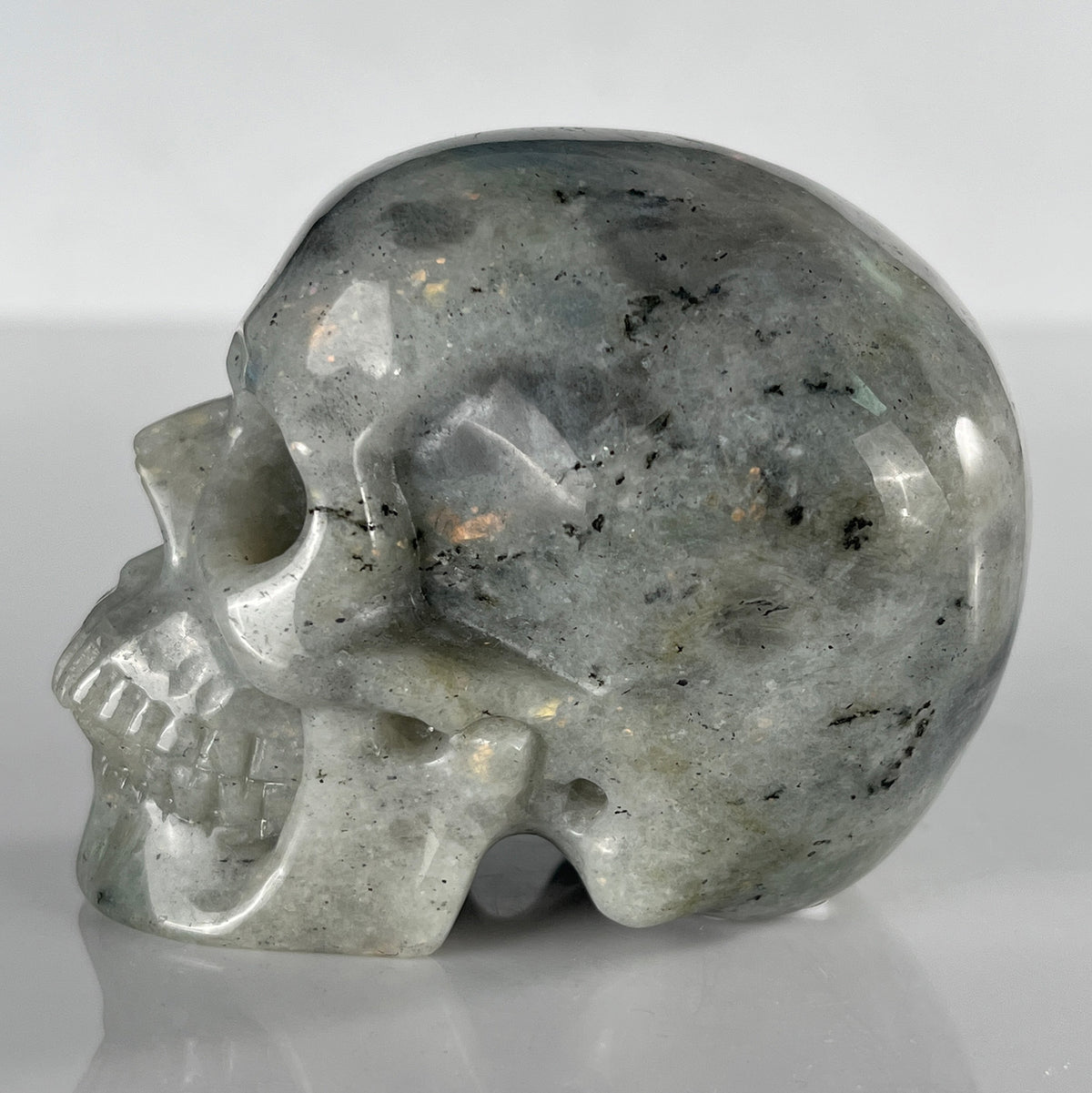 Left view of a 3-inch Grey Labradorite human skull carving
