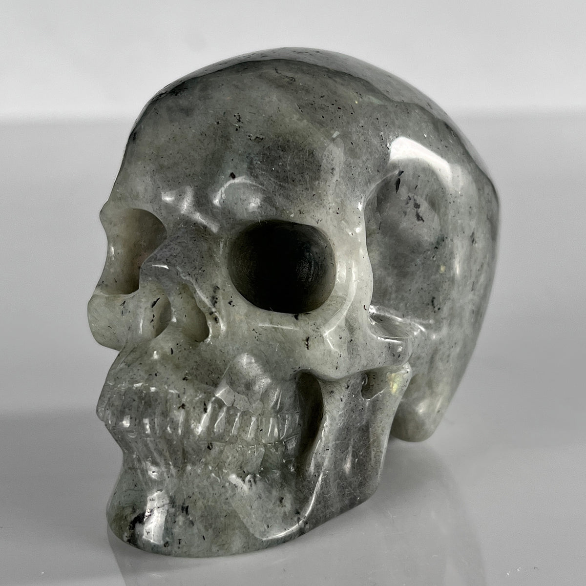 Left-front view of a 3-inch Grey Labradorite human skull carving