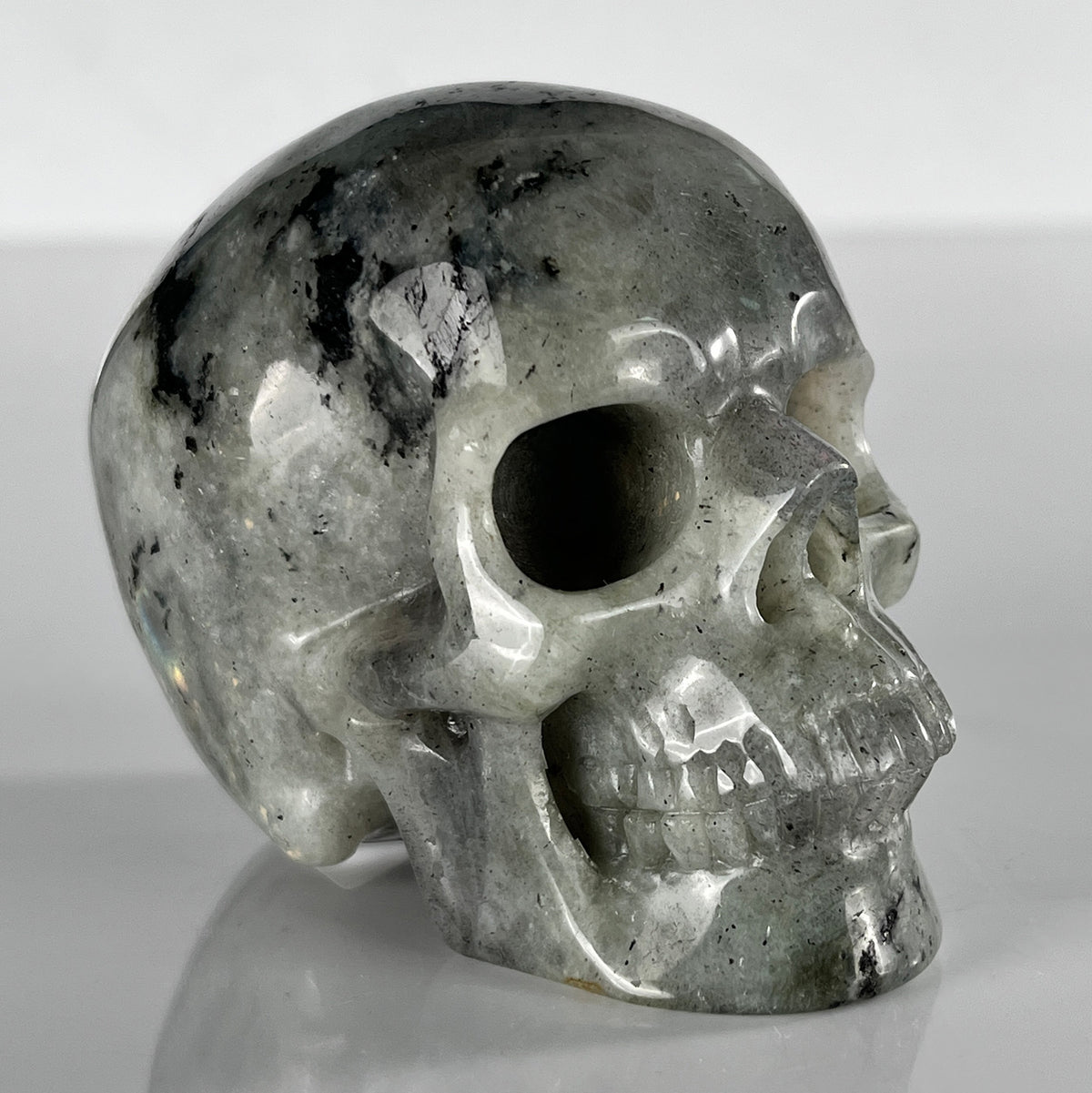 Right-front view of a 3-inch Grey Labradorite human skull carving