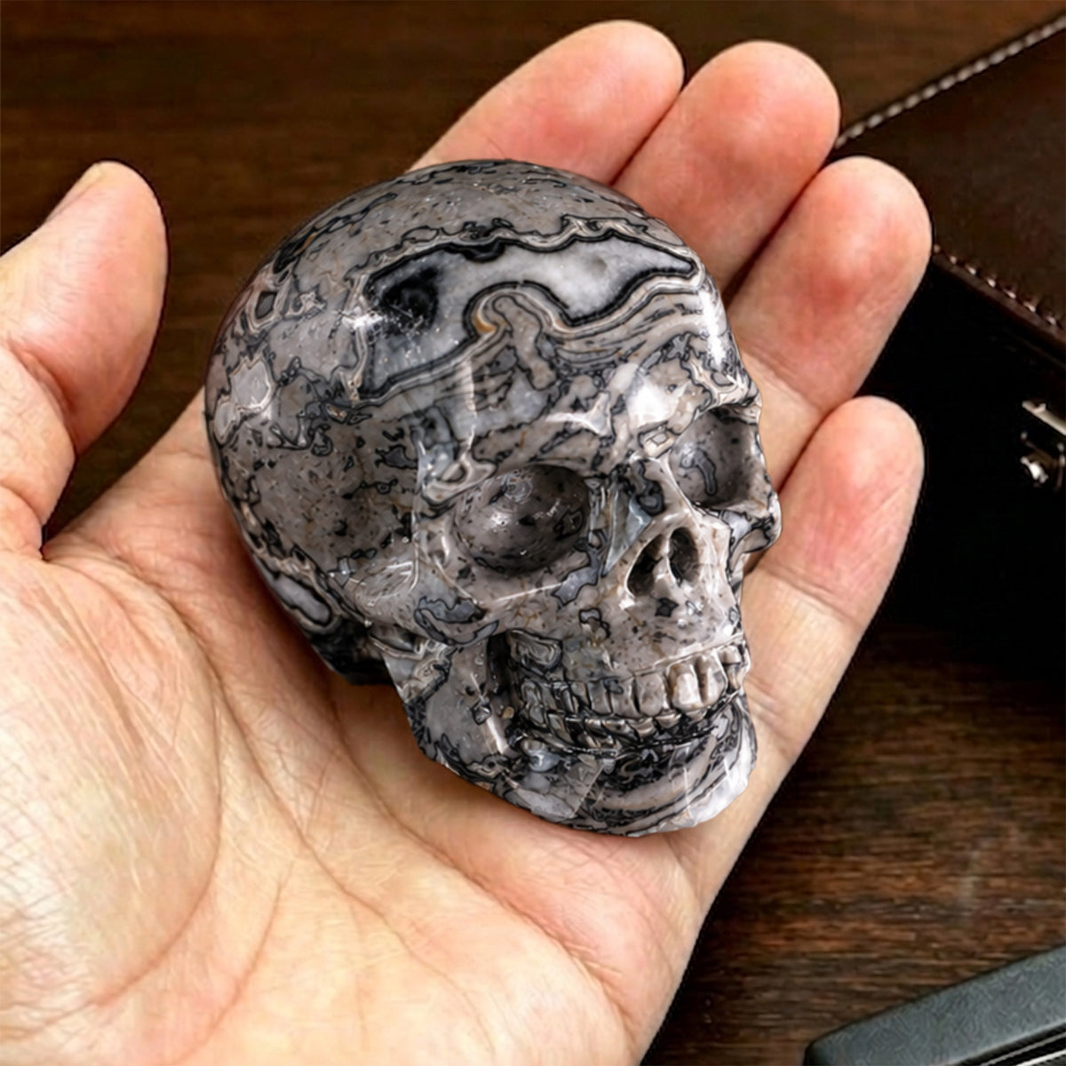 Additional view of a 2-inch Grey Picture Jasper human skull carving