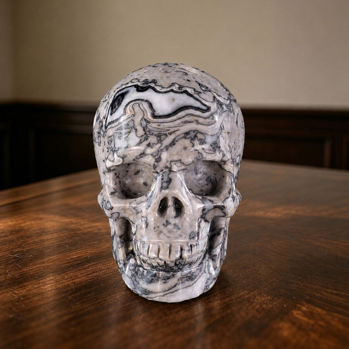 Front view of a 2-inch Grey Picture Jasper human skull carving