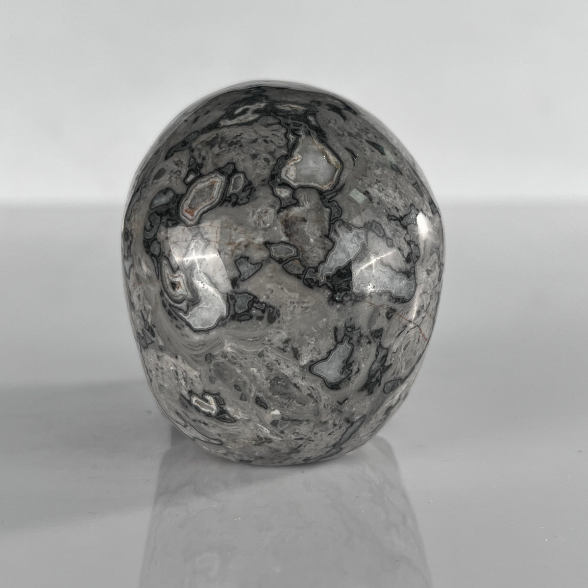 Back view of a 3-inch Grey Picture Jasper human skull carving