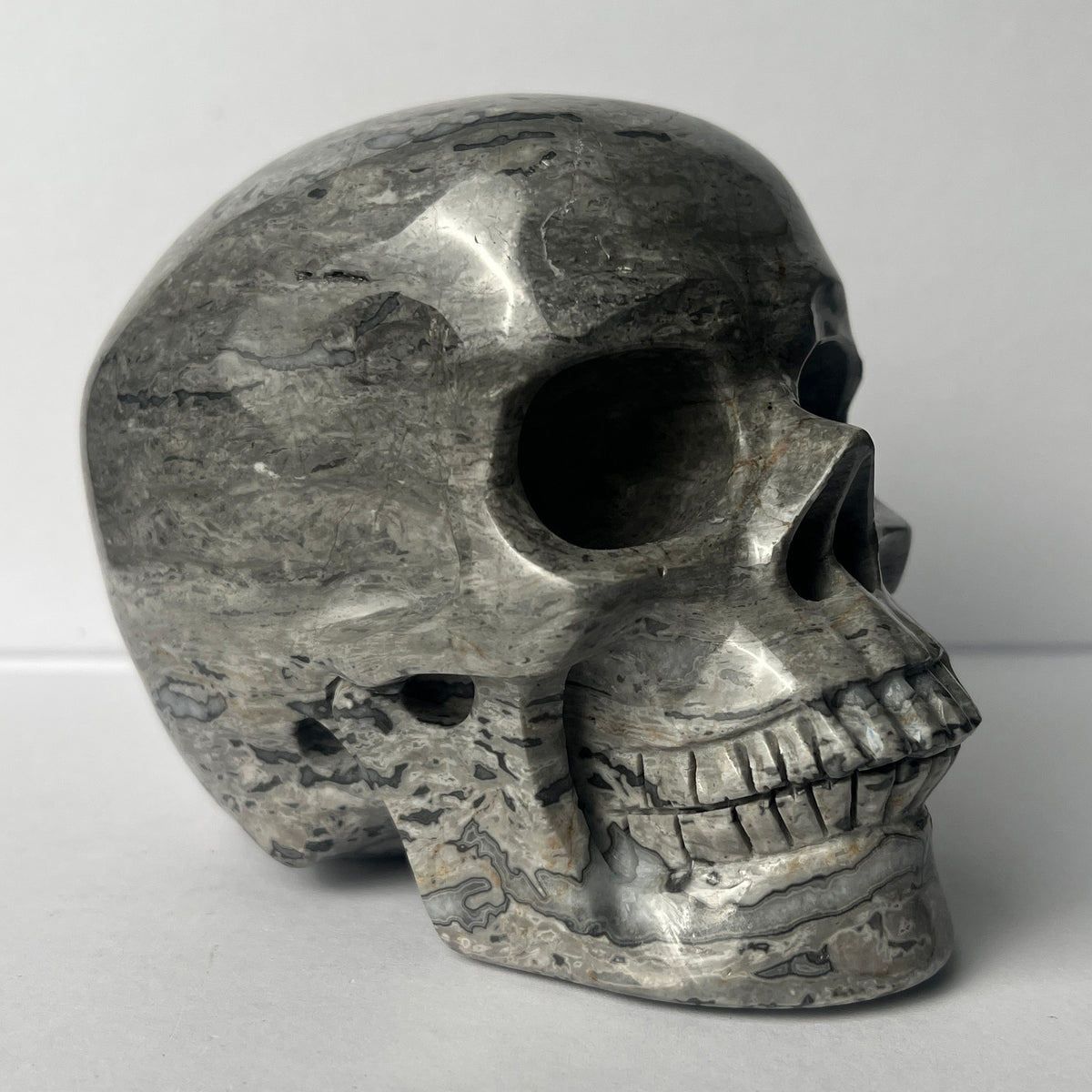Right-front view of a 4.5-inch Grey Picture Jasper human skull carving