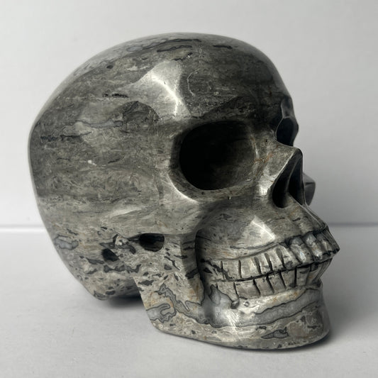 Right-front view of a 4.5-inch Grey Picture Jasper human skull carving