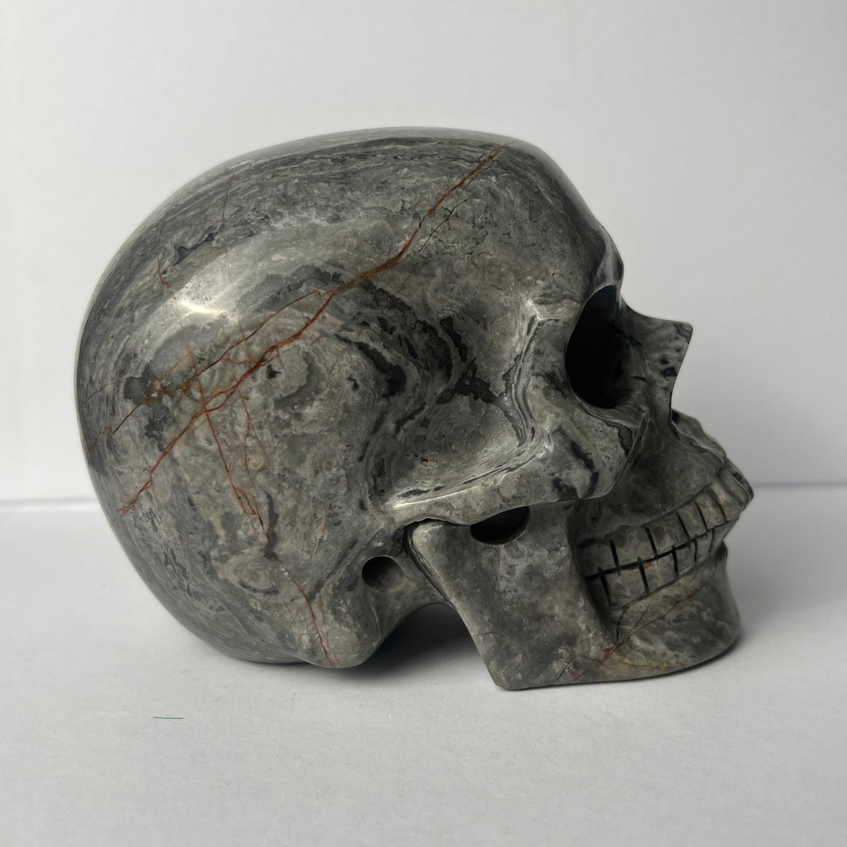 Right view of a 4.5-inch Grey Picture Jasper human skull carving
