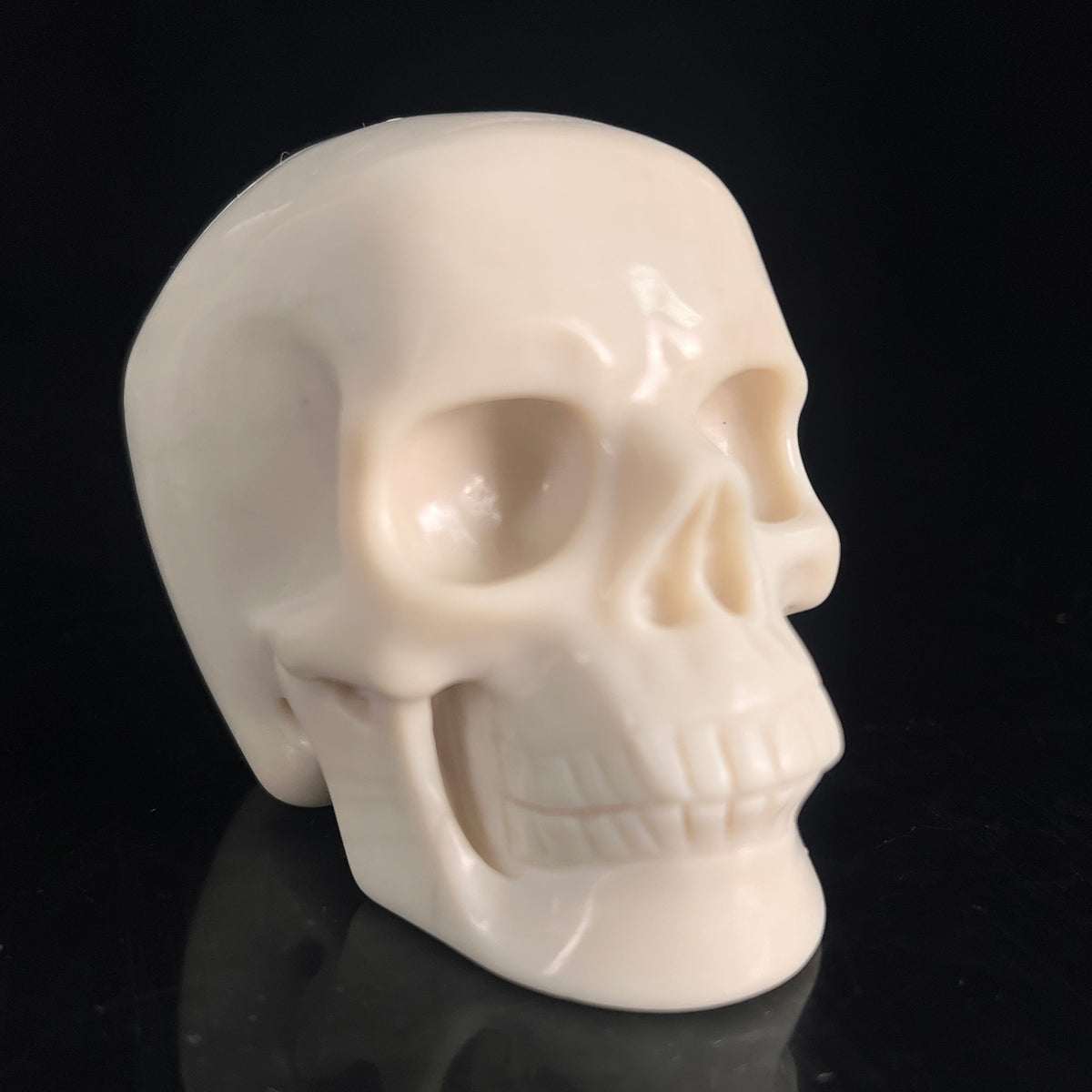 Right-front view of a 3-inch Ivory Jade human skull carving