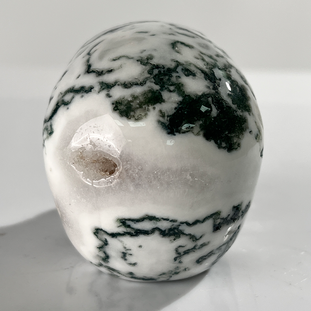 Back view of a 3-inch Moss Agate human skull carving