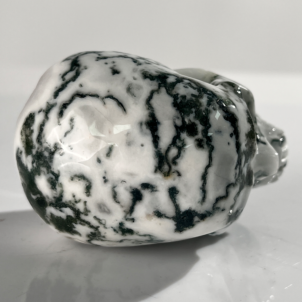 Top view of a 3-inch Moss Agate human skull carving
