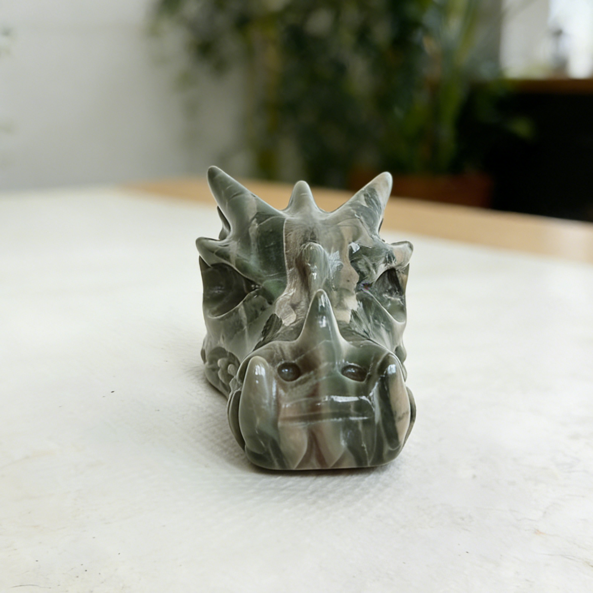 Additional view of a 3-inch Nine Dragon Jade dragon skull carving