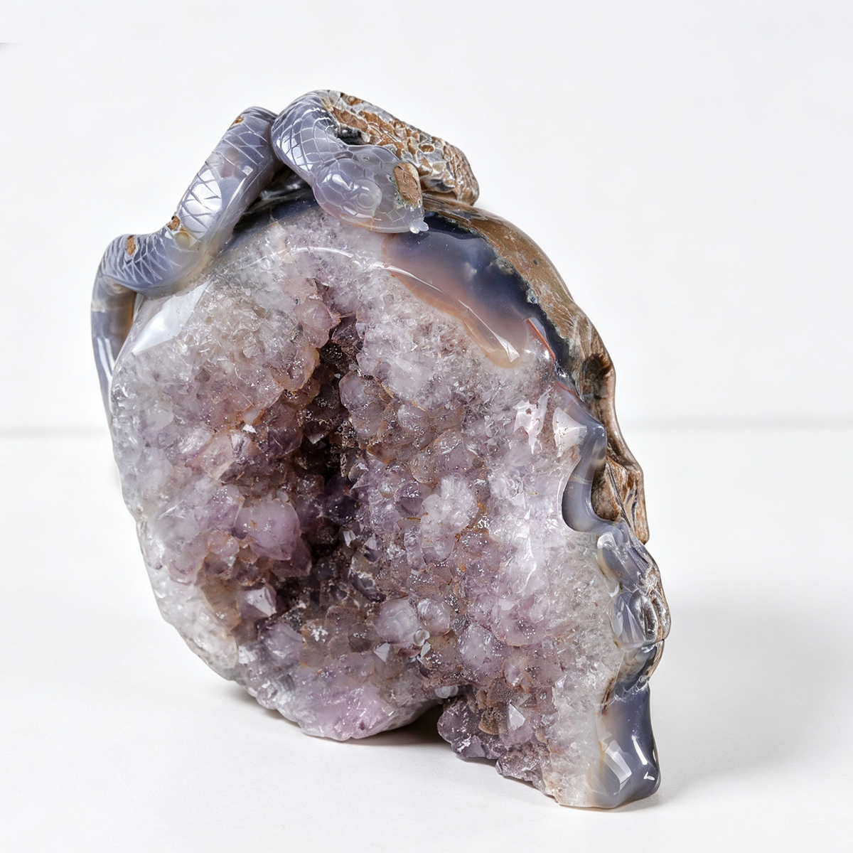Right-front view of a one-of-a-kind Amethyst geode skull and serpent sculpture