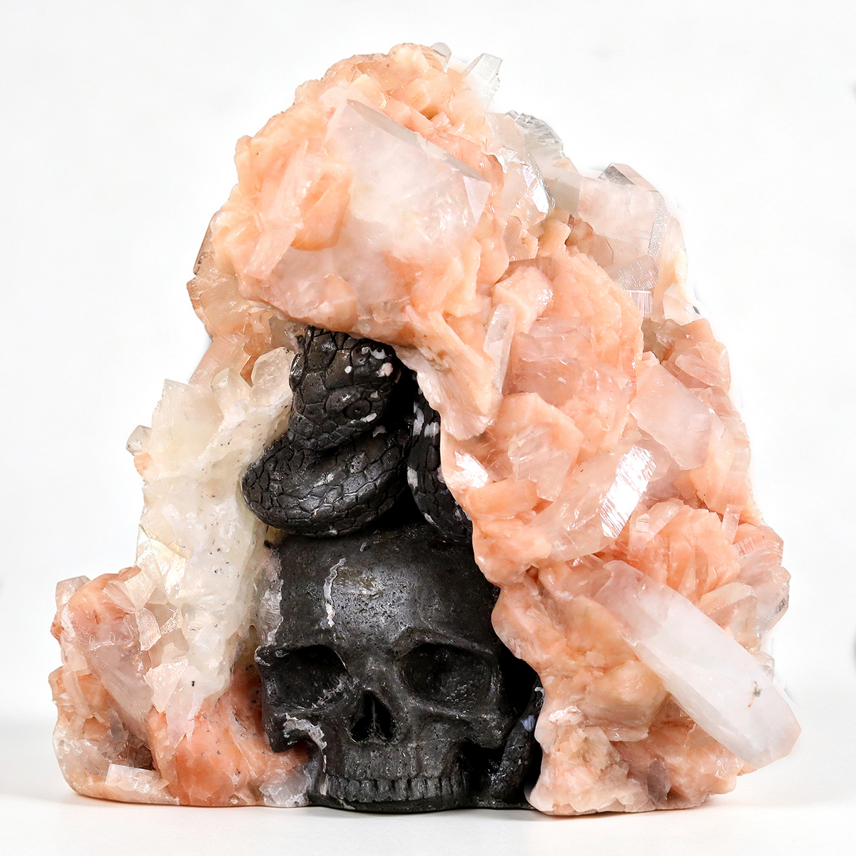 Left-front view of a one-of-a-kind Apophyllite and Stilbite geode with serpents and skulls sculpture