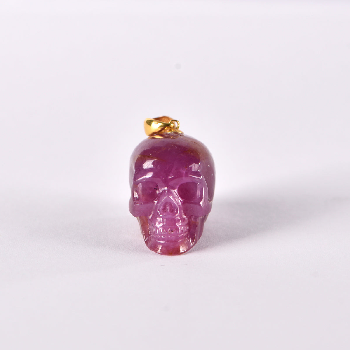 Front view of a one-of-a-kind Ruby skull pendant carving