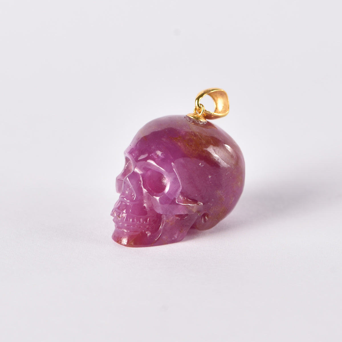 Left view of a one-of-a-kind Ruby skull pendant carving