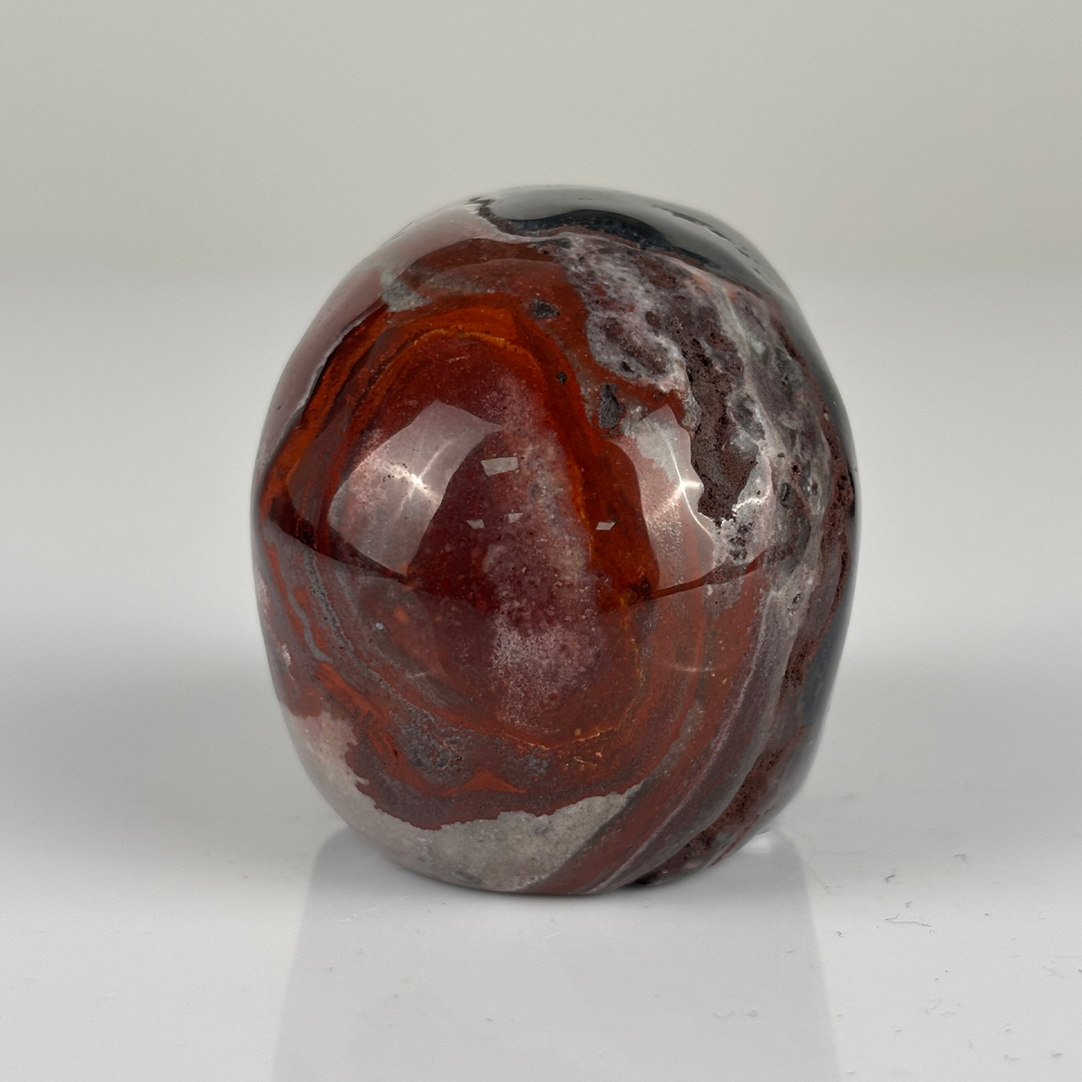 Back view of a 2-inch Red Crazy Lace Agate human skull carving