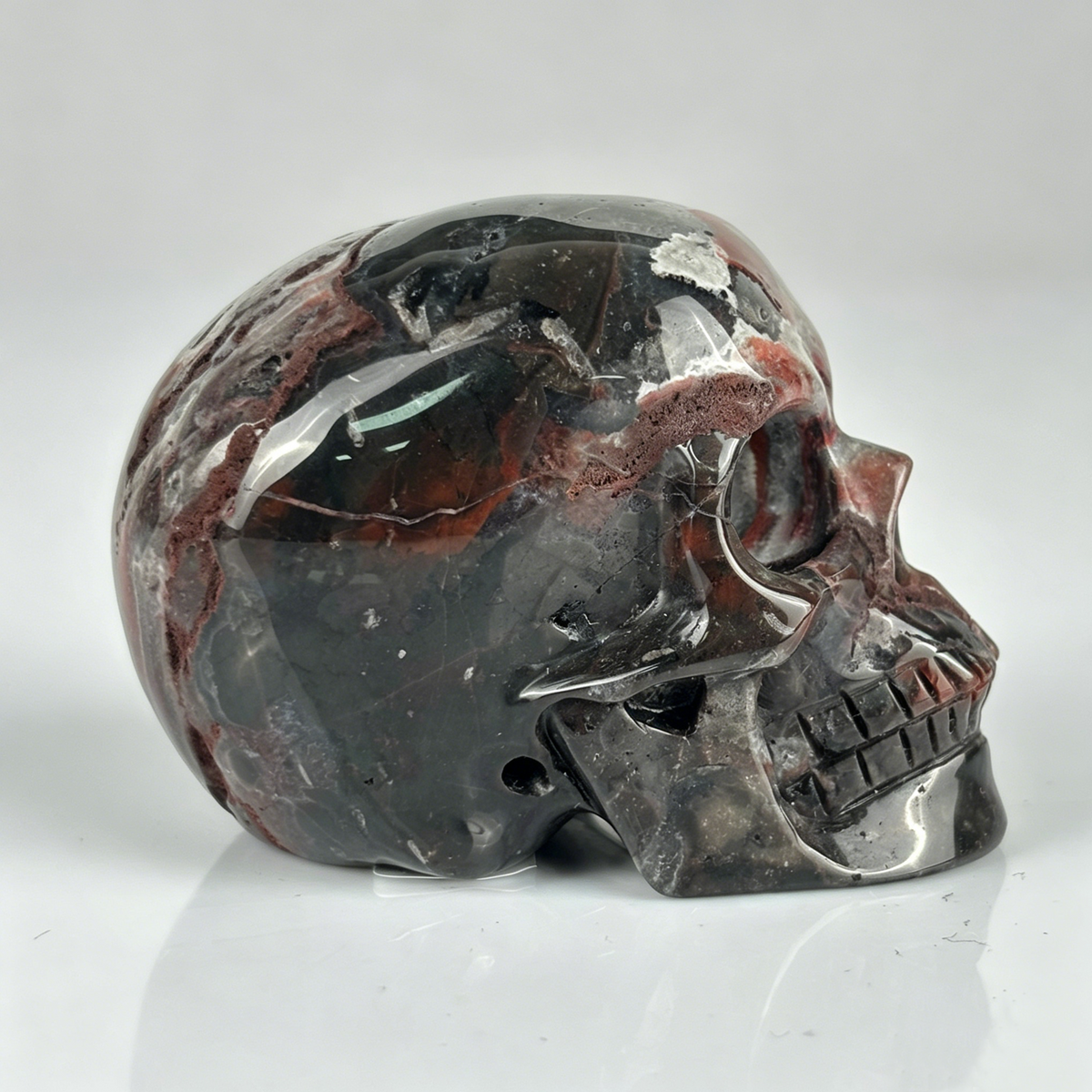 Right view of a 2-inch Red Crazy Lace Agate human skull carving
