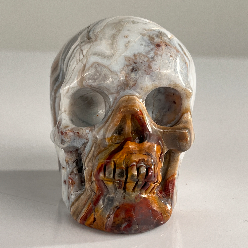 Front view of a 3-inch Red Crazy Lace Agate human skull carving