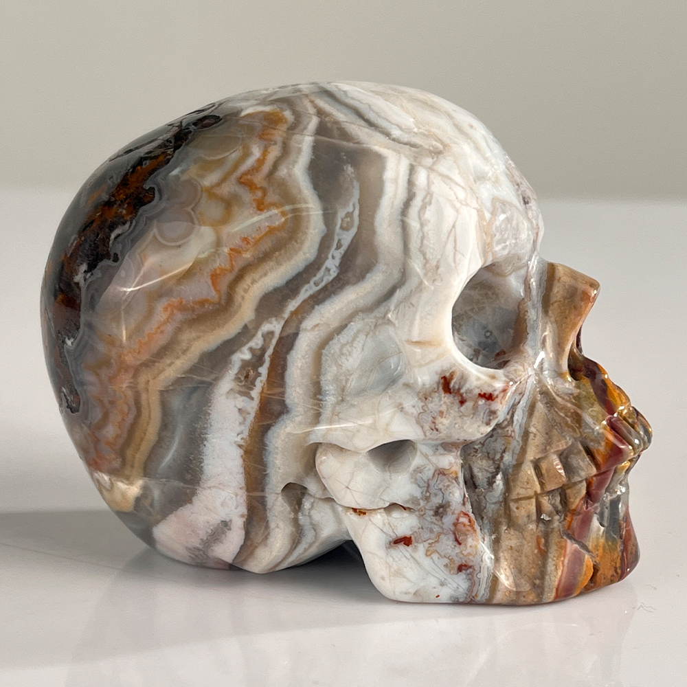 Right view of a 3-inch Red Crazy Lace Agate human skull carving