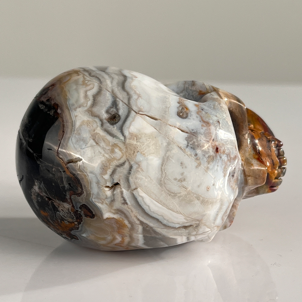 Top view of a 3-inch Red Crazy Lace Agate human skull carving