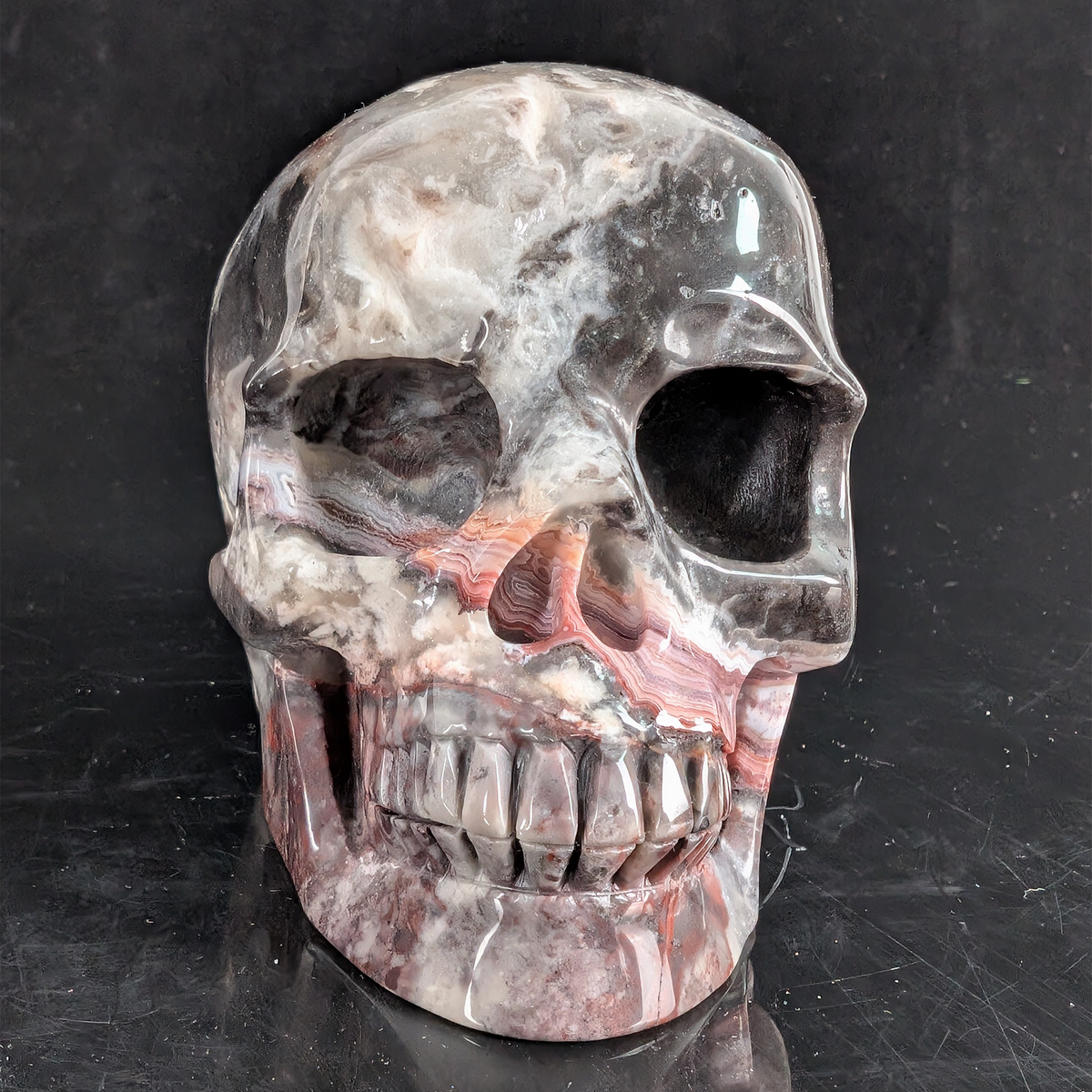 Front view of a 4.5-inch Red Crazy Lace Agate human skull carving