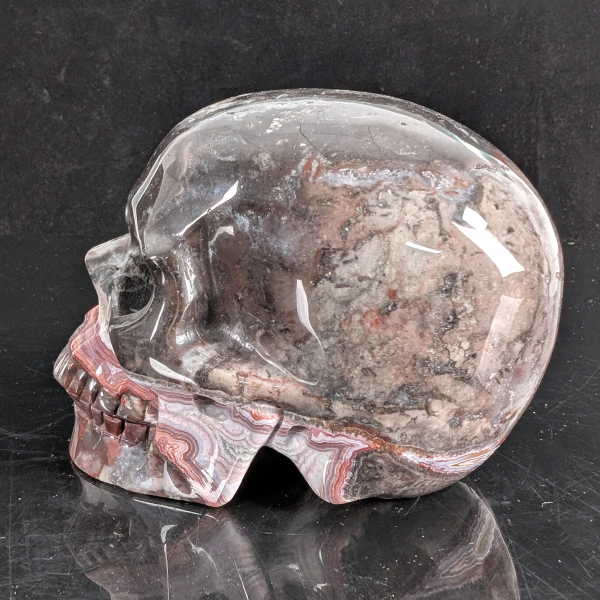 Left view of a 4.5-inch Red Crazy Lace Agate human skull carving