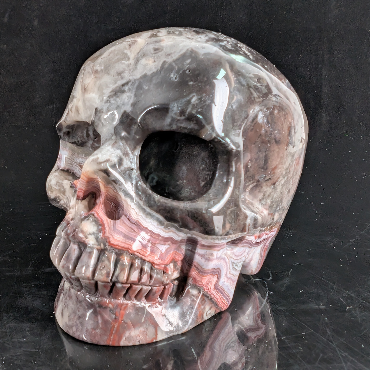Left-front view of a 4.5-inch Red Crazy Lace Agate human skull carving