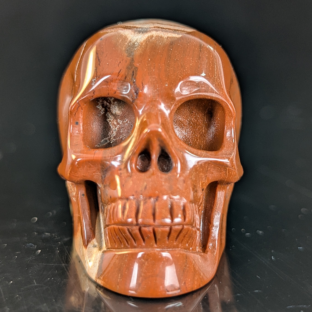 Front view of a 2-inch Red Jasper human skull carving