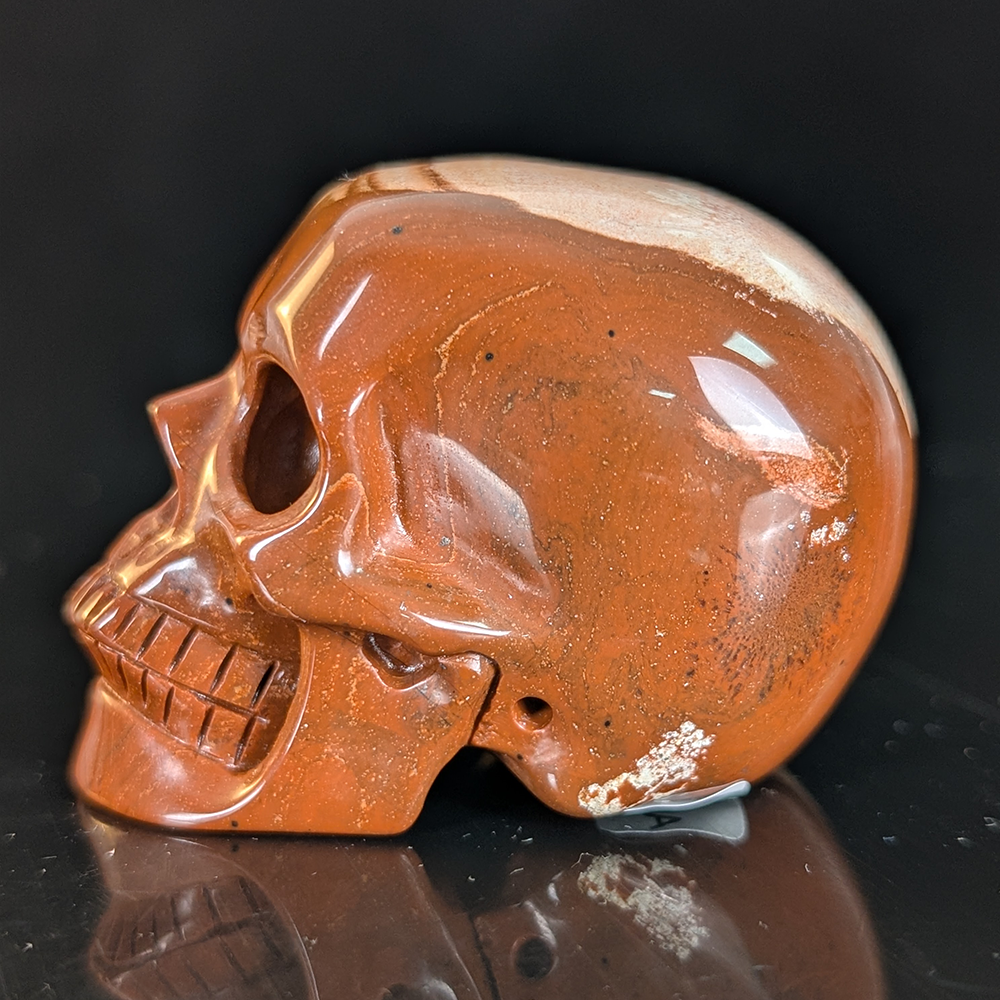 Left view of a 2-inch Red Jasper human skull carving
