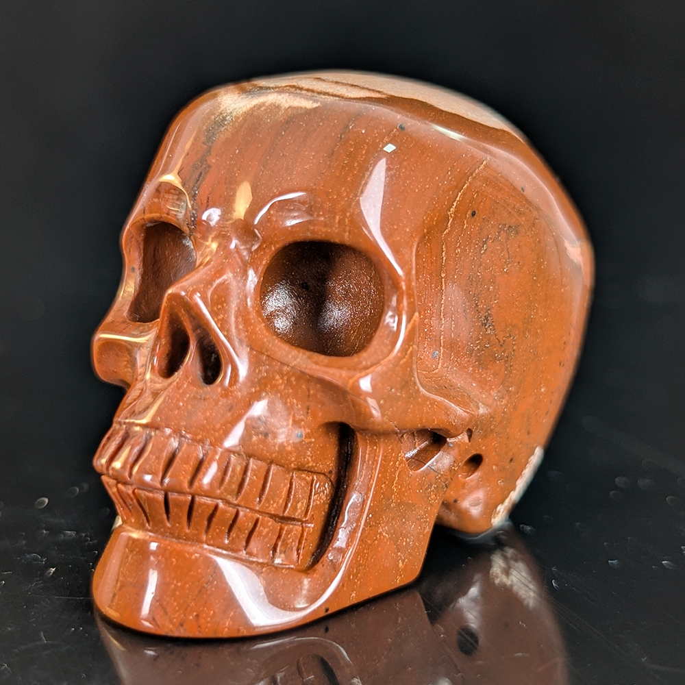 Left-front view of a 2-inch Red Jasper human skull carving