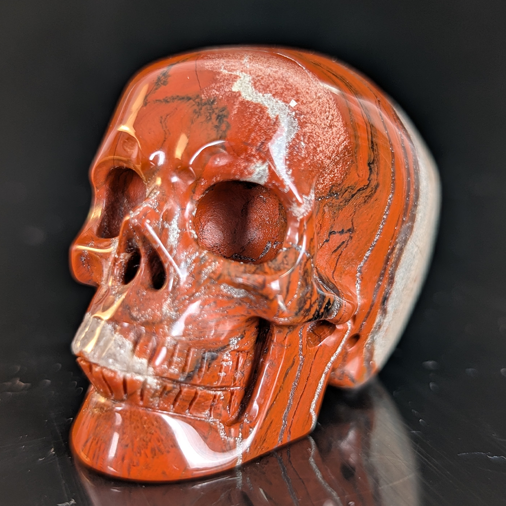 Left-front view of a 2-inch Red Jasper human skull carving