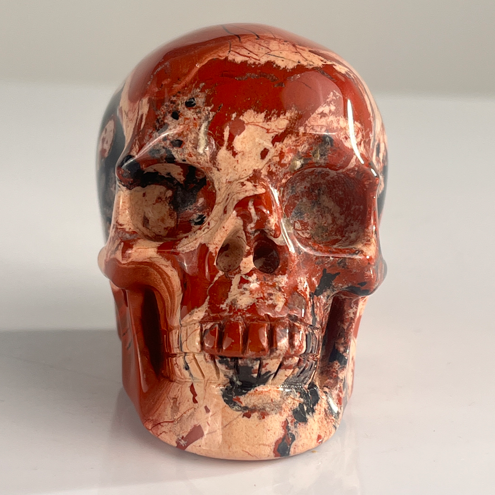 Front view of a 3-inch Red Jasper human skull carving
