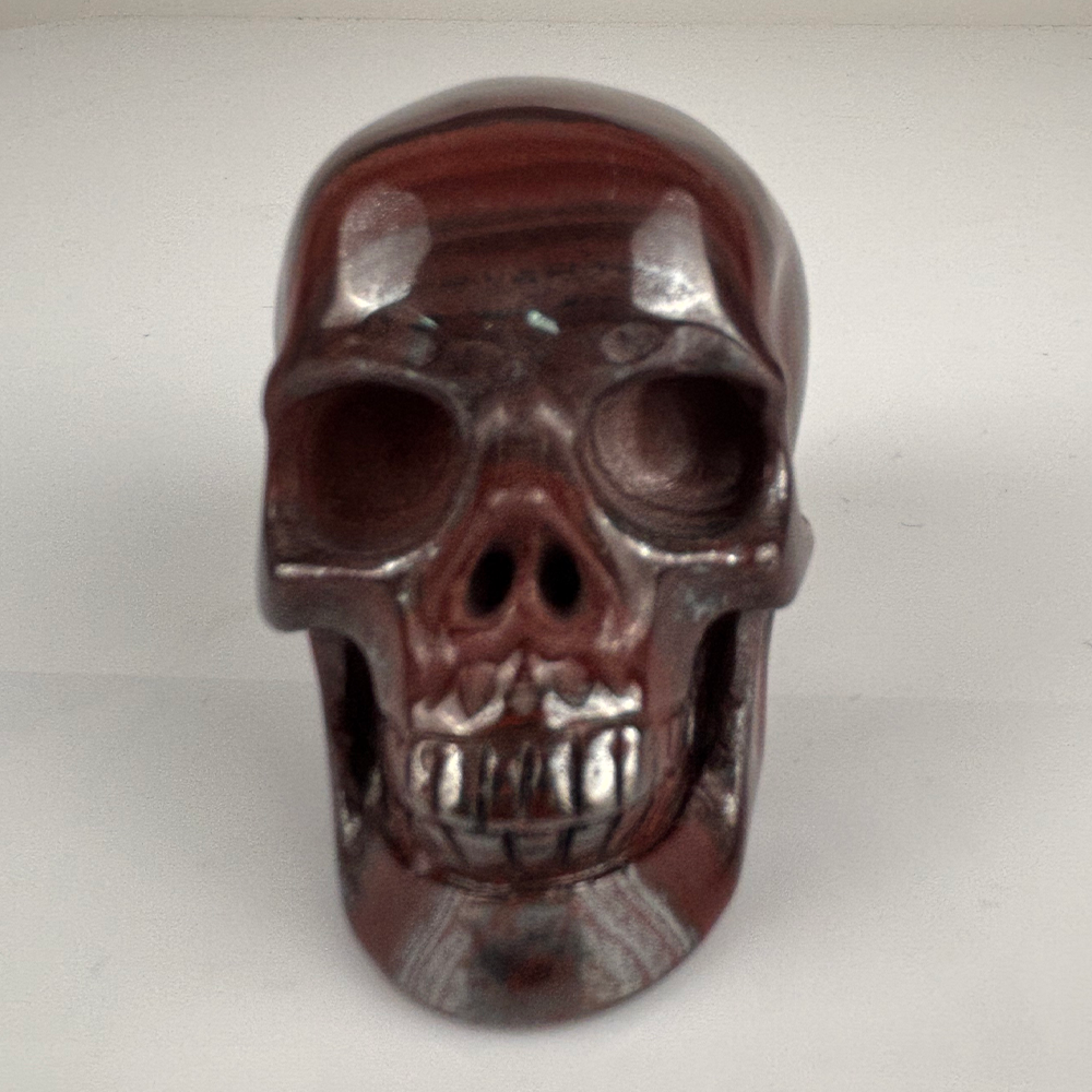 Front view of a 2-inch Tiger Iron human skull carving