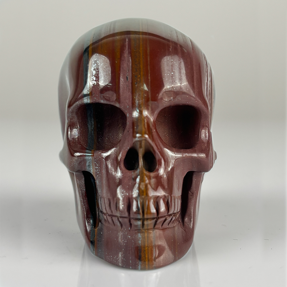 Front view of a 2-inch Tiger Iron human skull carving