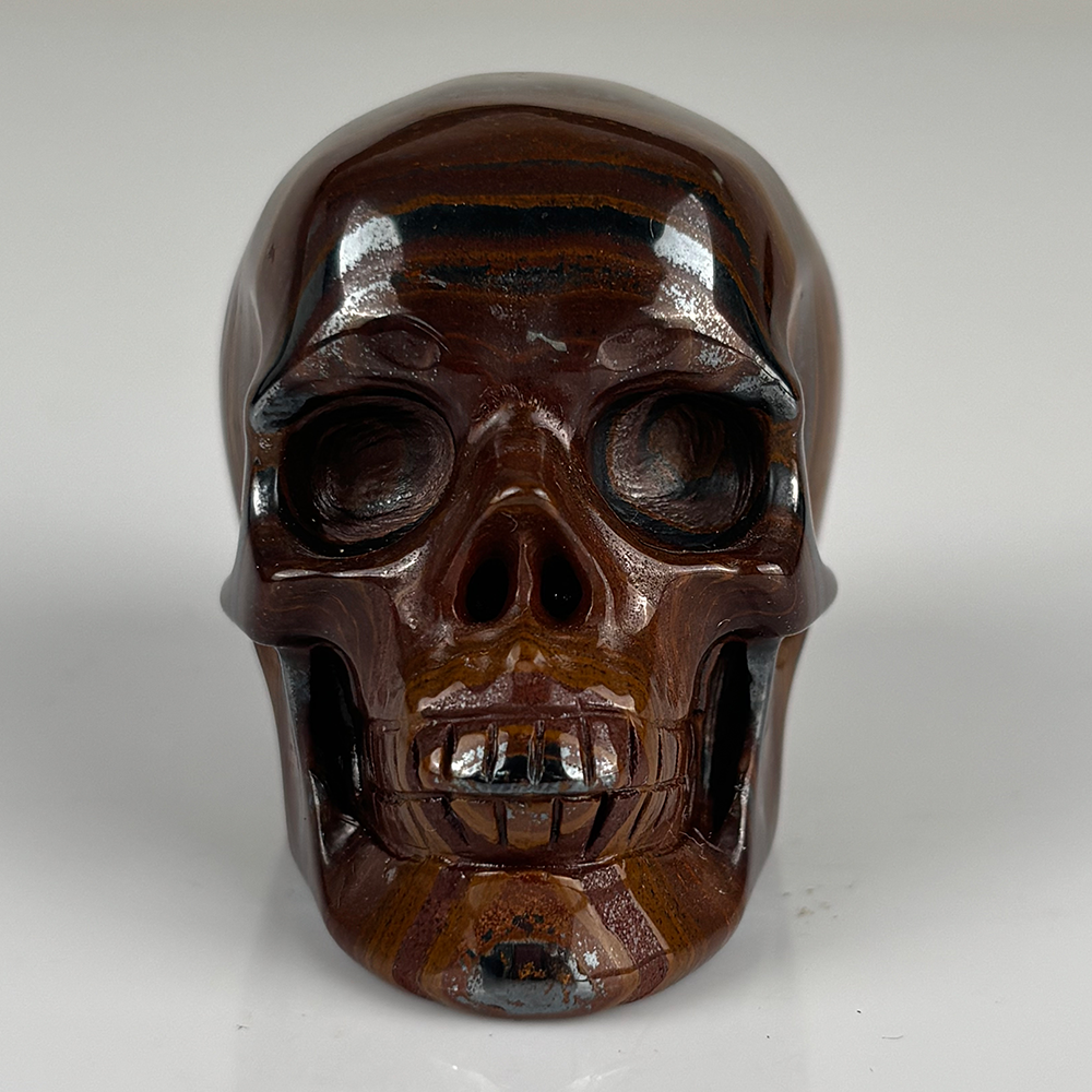 Front view of a 2-inch Tiger Iron human skull carving