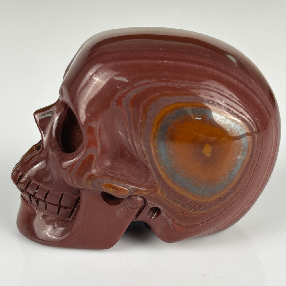 Left view of a 2-inch Tiger Iron human skull carving