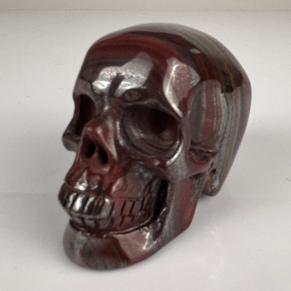 Left-front view of a 2-inch Tiger Iron human skull carving