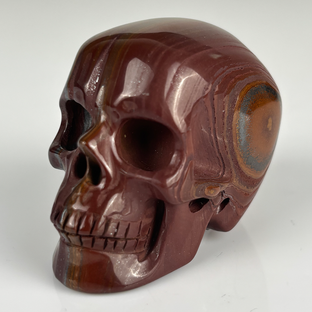 Left-front view of a 2-inch Tiger Iron human skull carving