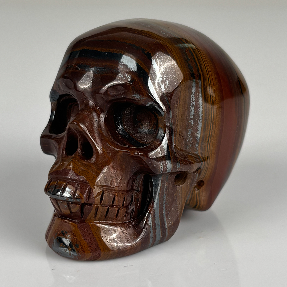 Left-front view of a 2-inch Tiger Iron human skull carving