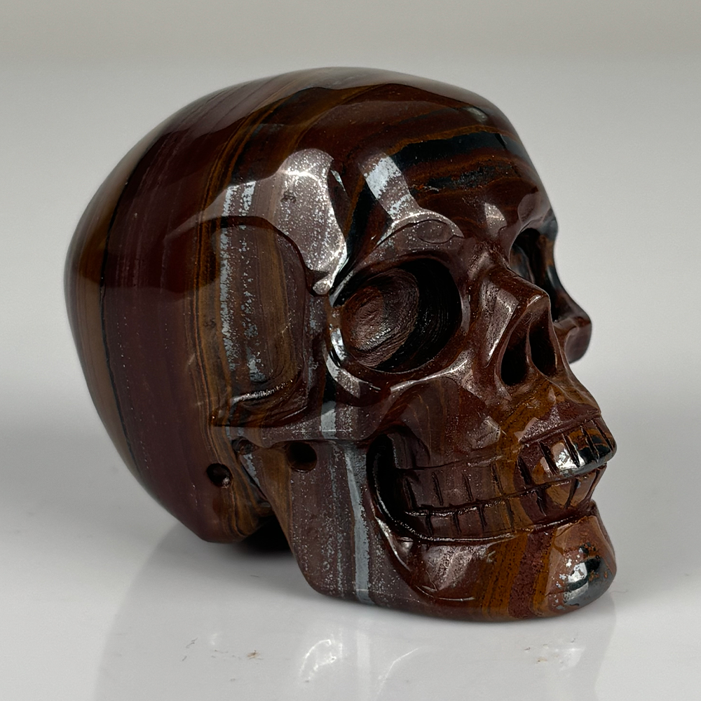 Right-front view of a 2-inch Tiger Iron human skull carving
