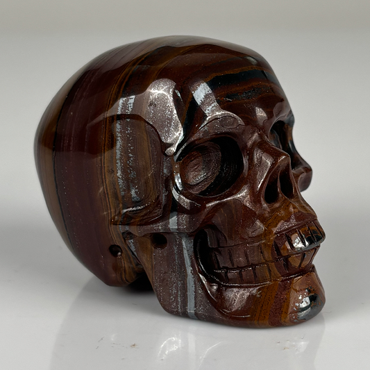 Right-front view of a 2-inch Tiger Iron human skull carving