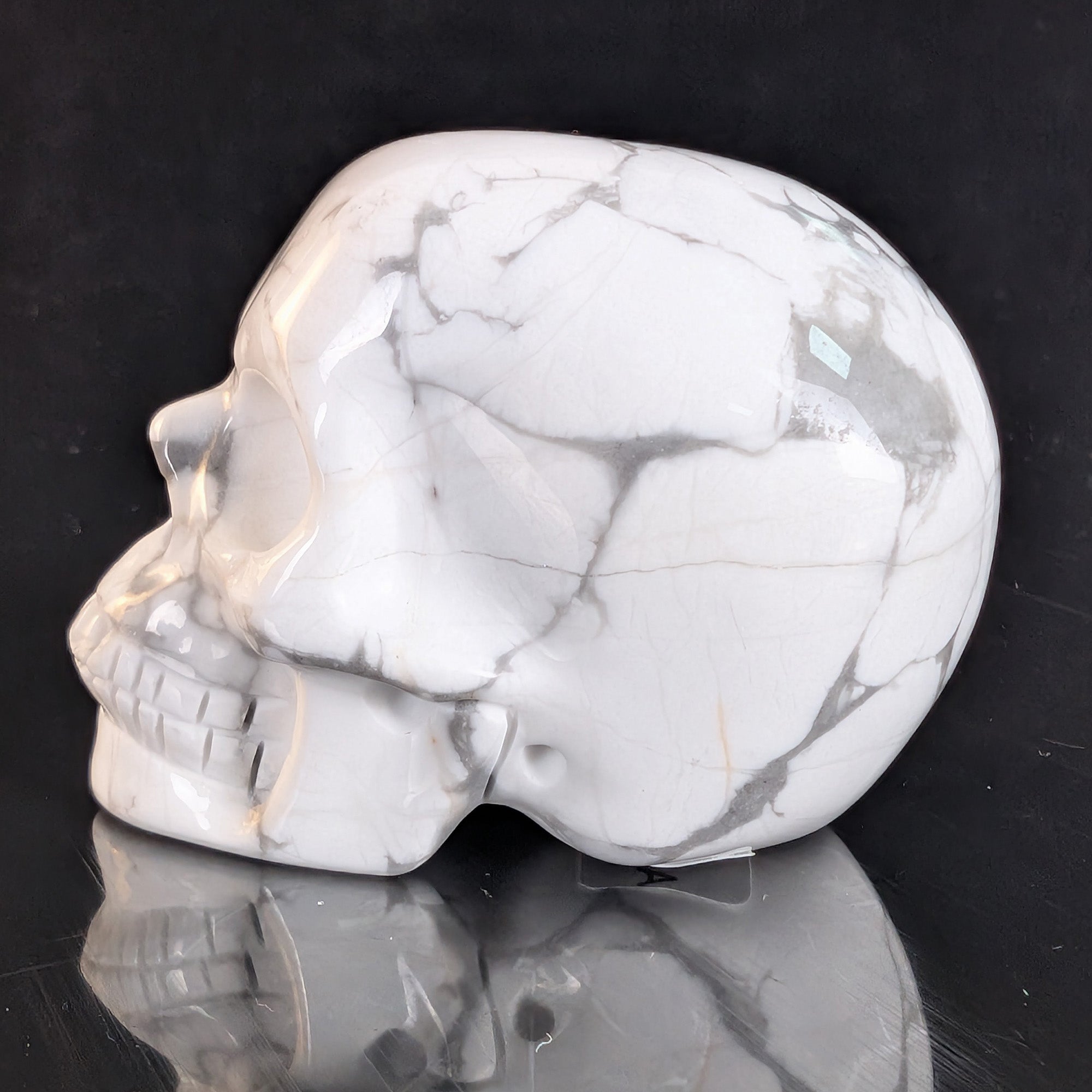 Left view of a 2-inch White Howlite human skull carving