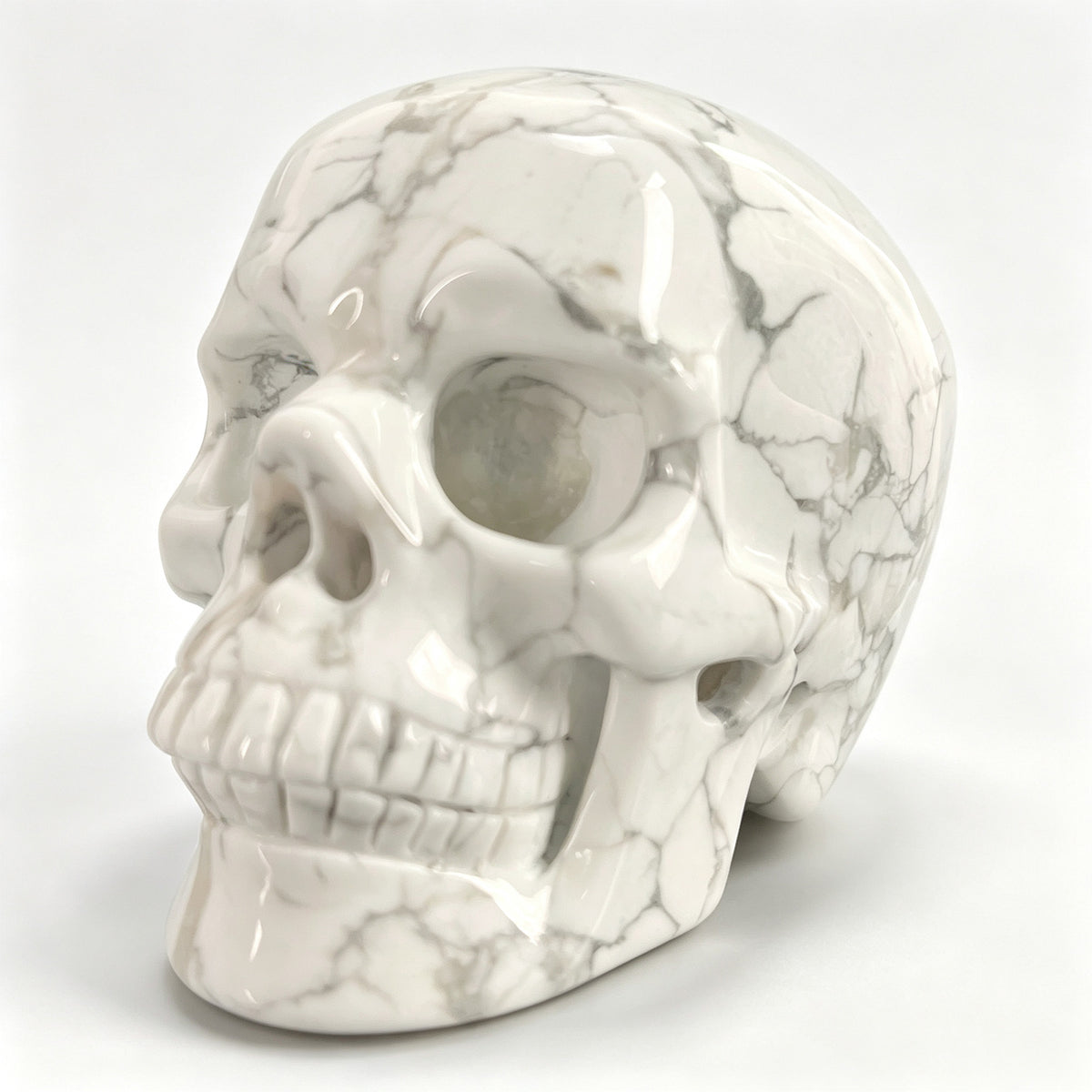 Left-front view of a 3-inch White Howlite human skull carving