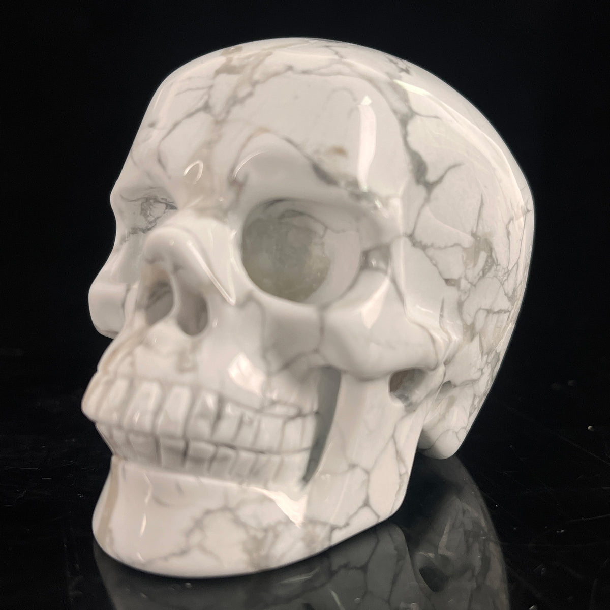 Left-front view of a 3-inch White Howlite human skull carving