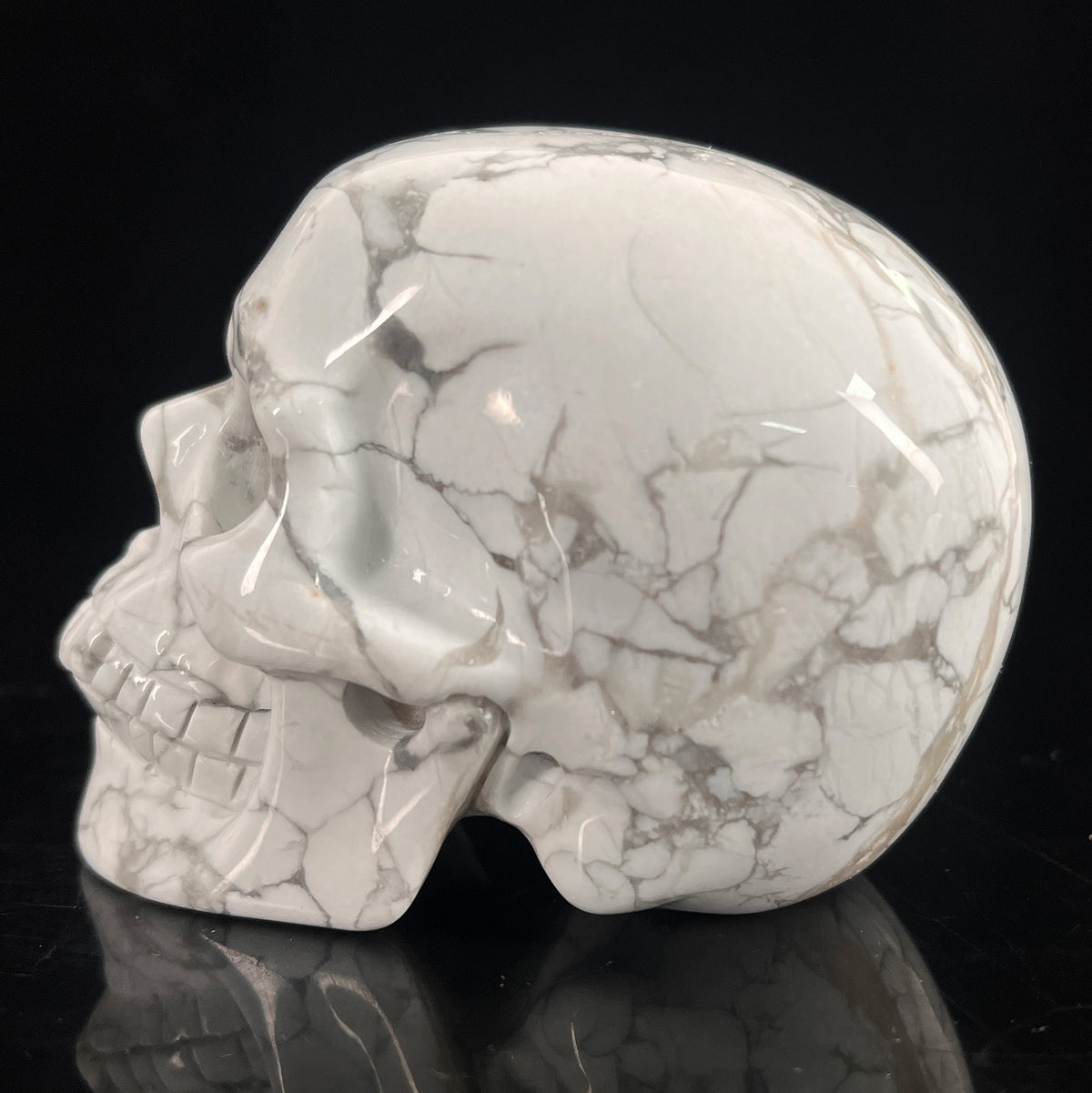 Left view of a 3-inch White Howlite human skull carving