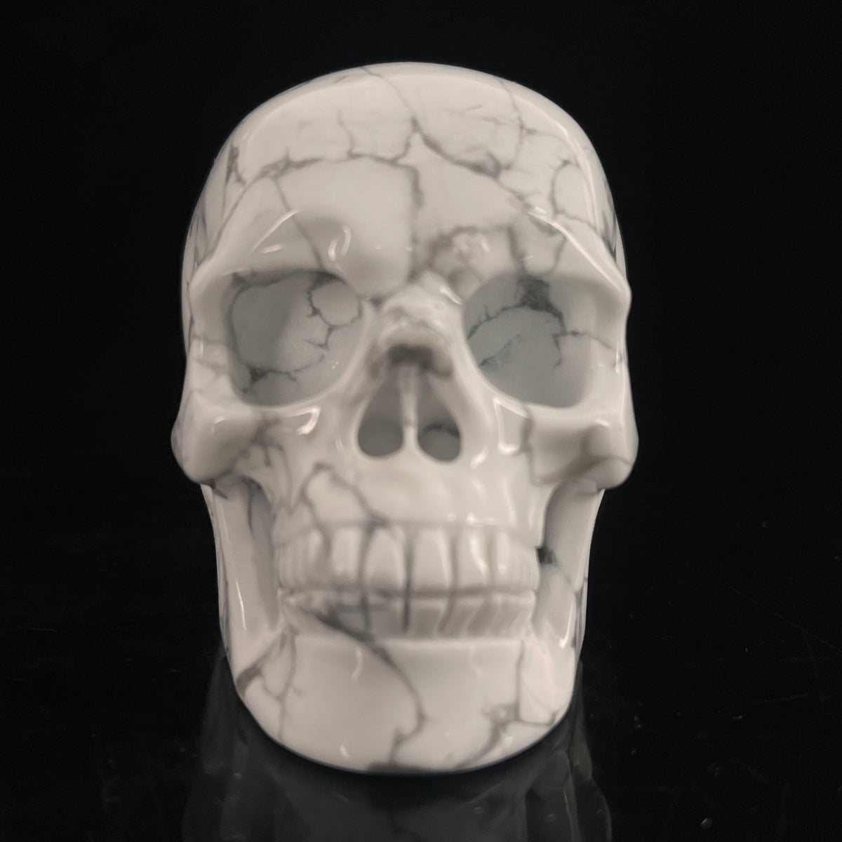 Front view of a 3-inch White Howlite human skull carving