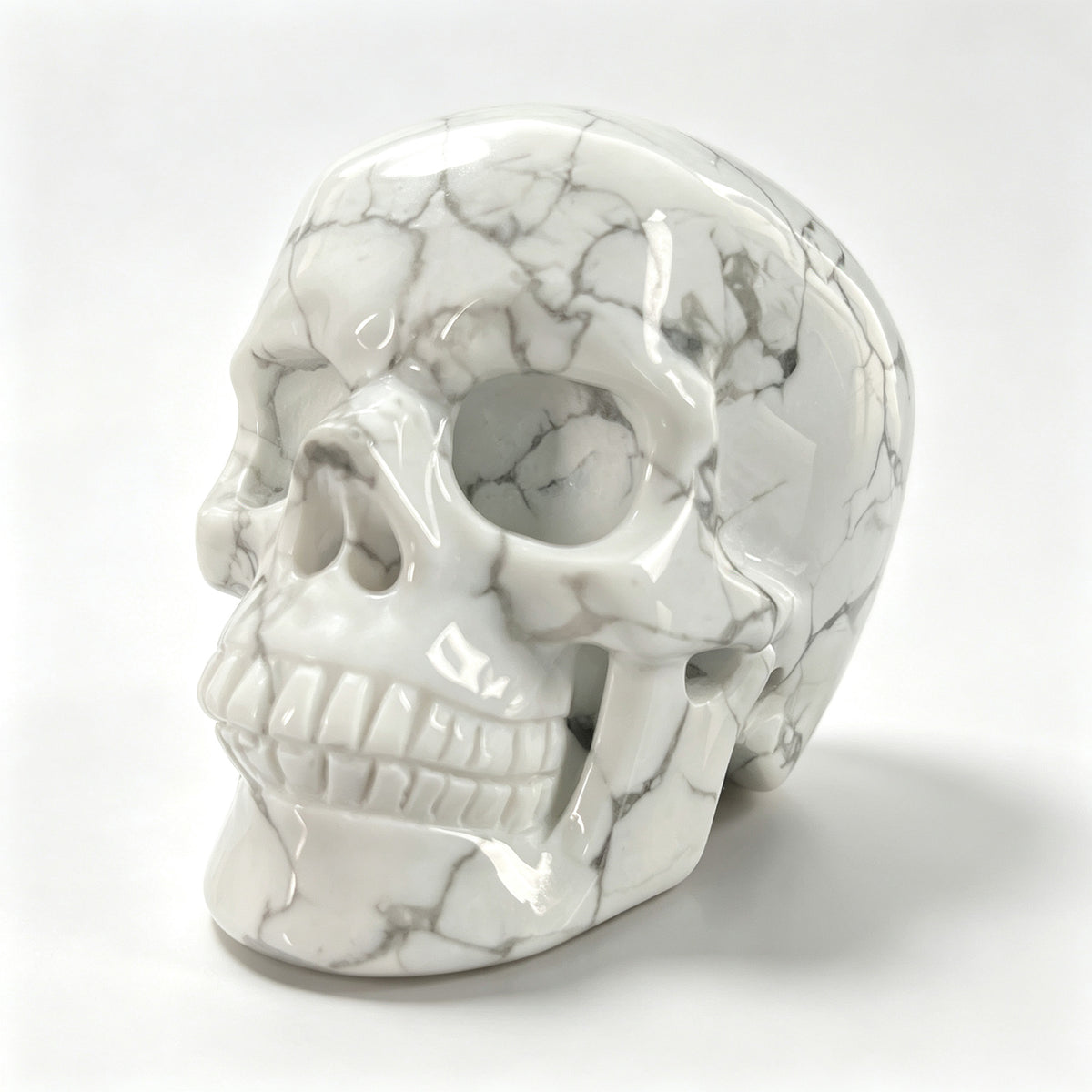 Left-front view of a 3-inch White Howlite human skull carving