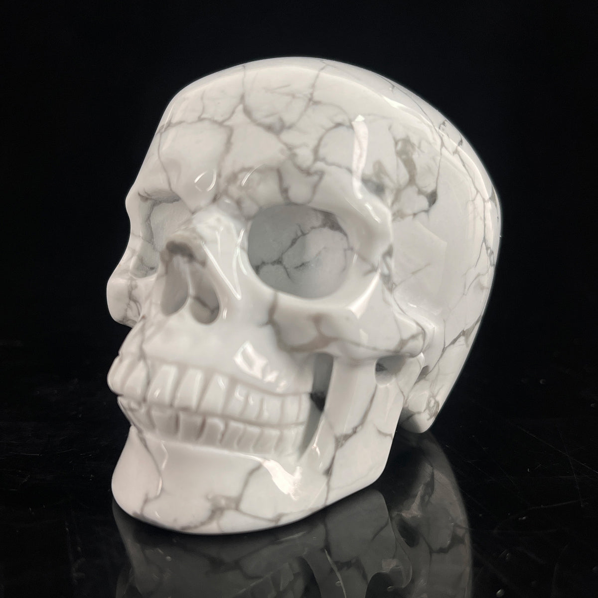Left-front view of a 3-inch White Howlite human skull carving
