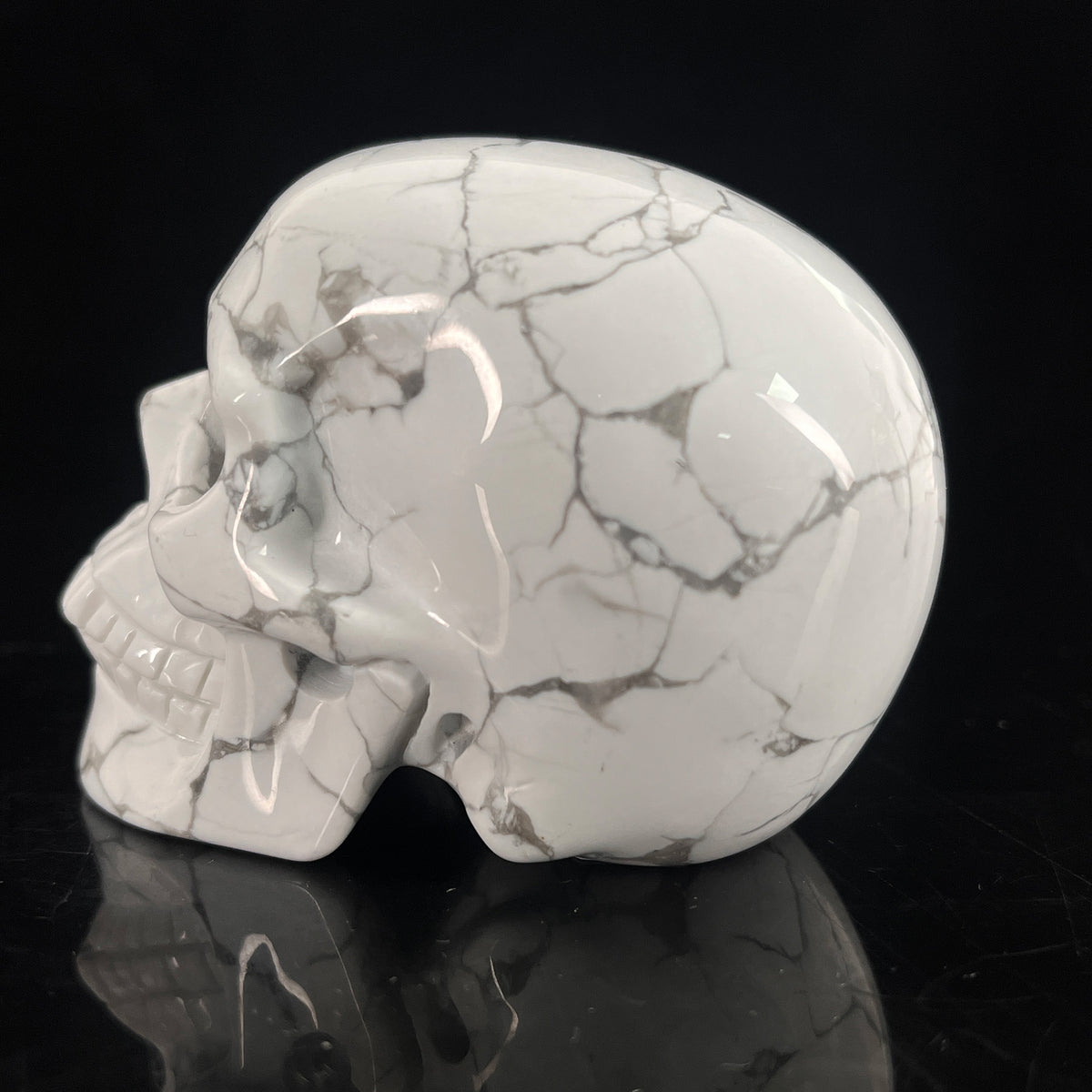 Left-side view of a 3-inch White Howlite human skull carving