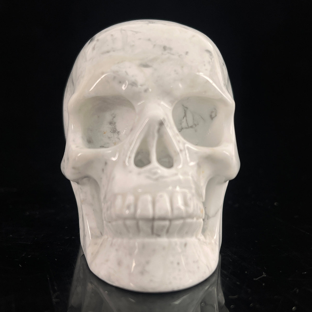 Front view of a 3-inch White Howlite human skull carving